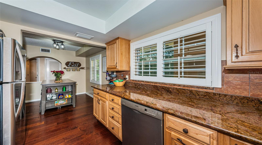 Well Appointed Kitchen With Granite Counters, Stainless Appliances, Privacy Shutters, And Wood Cabinets.