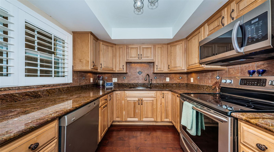 Well Appointed Kitchen With Granite Counters, Stainless Appliances, Privacy Shutters, And Wood Cabinets.