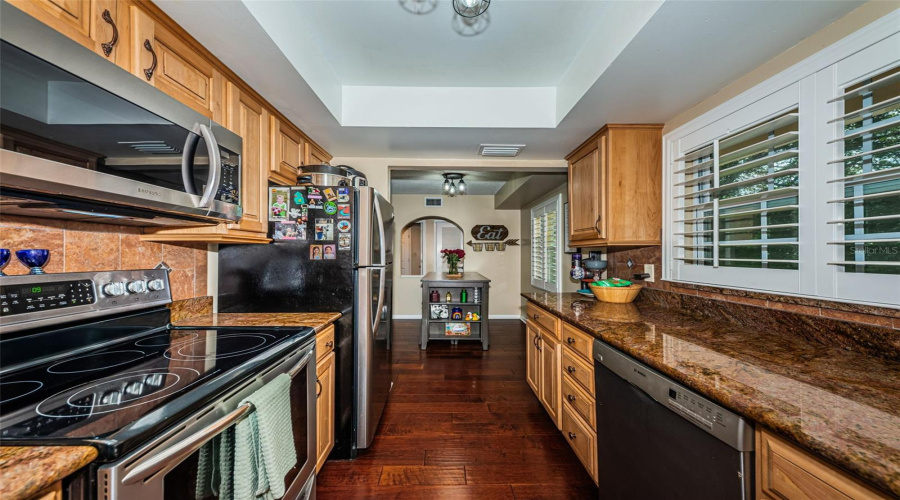 Well Appointed Kitchen With Granite Counters, Stainless Appliances, Privacy Shutters, And Wood Cabinets.