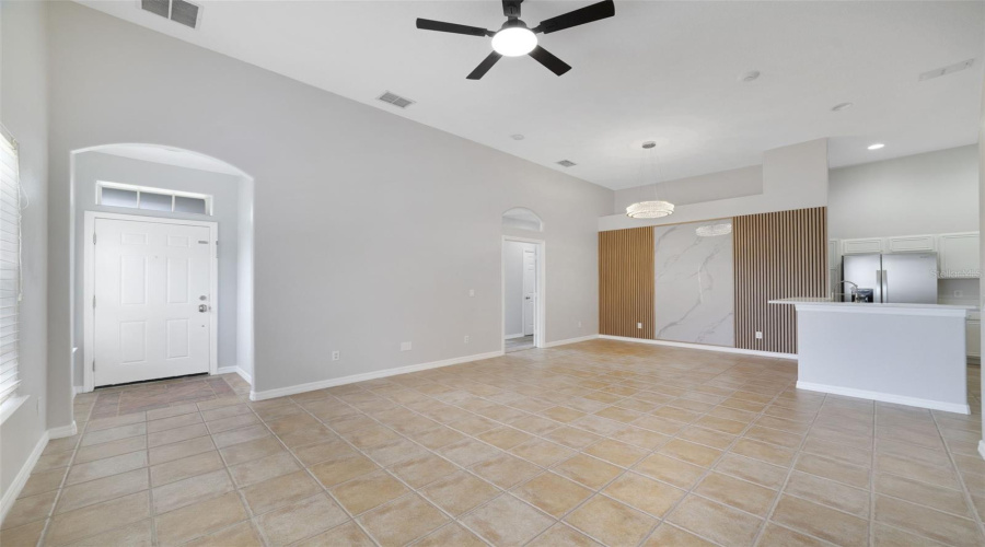 Step Inside Through The Graceful Architectural Archway To A Bright And Welcoming Open Floor Plan Where The Living Room, Dining Area And Kitchen Flow Effortlessly Together, And Easy-Care Tile Flooring Runs Throughout These Main Living Spaces, Creating A Clean, Cohesive Feel.