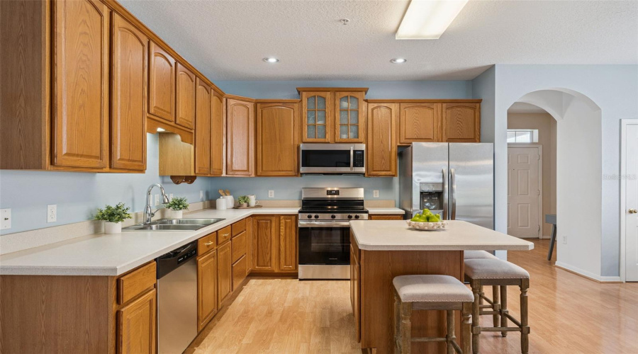 The Open Kitchen Features Ample Cabinetry And Counter Space, Pantry Storage, Stainless Steel Appliances And A Center Island With Casual Bar Seating, All Overlooking The Main Living Area.