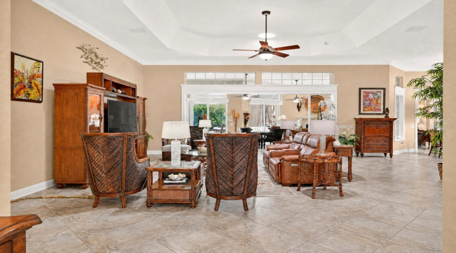 Living Room View From Foyer - Shows The Capacious Living Room W/ Large Diagonal Set Tile, 12' Ceiling, Crown Molding And Octagonal Shaped Tray Ceiling. The White Wood Cornice &Amp; Woodworking Highlight The Large Set Of Stack Back Sliding Glass Doors And The Overhead Transom.