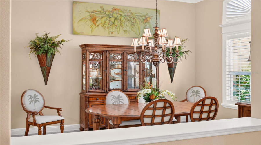 View Of Formal Dining Room From Foyer - Note Matching Ornate Chandelier Centered Over The Dining Roomtable.