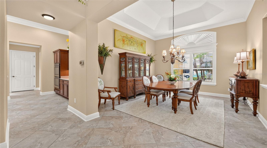 View Of Formal Dining Room - With An Eastern Front Exposure For Abundant Natural Light, This Elegant Area With Plantation Shutters, Wood Cornice, Crown Molding, And A Continuation Of The 20&Quot; X 20&Quot; Diagonal Set Tile Flooring Is The Perfect Setting For Entertaining Guests For Dinner! Dining Room Table (W/ Table Leaf) &Amp; 6 Chairs Manufactured By Lexington Home Brands. Lighted China Cabinet/Hutch &Amp; Buffet/Sideboard Manufactured By Broyhill.
