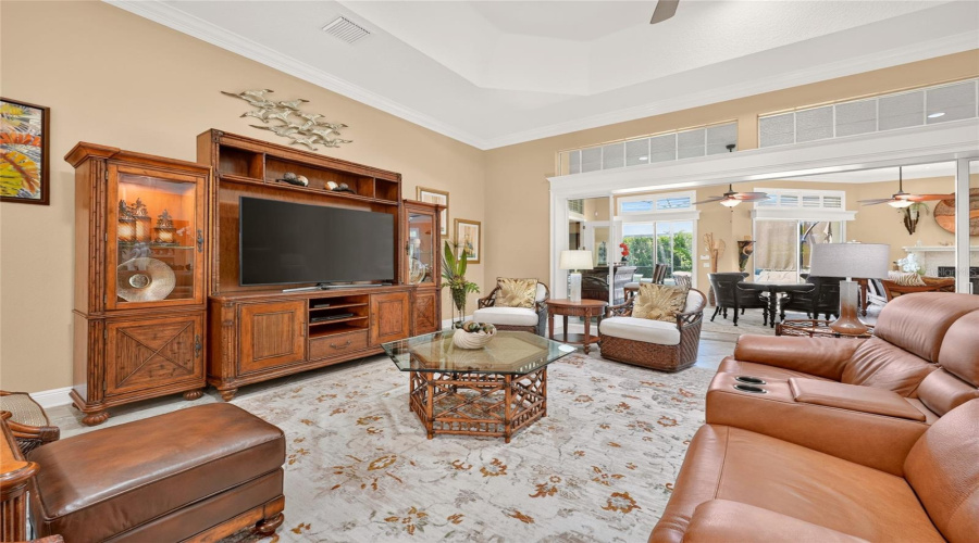 Living Room - This 26' X 25' Space Has A Lovely Wall Entertainment Center From The &Quot;Pelican Cay Media Console &Amp; Entertainment Deck&Quot; (Center), Which Are Part Of Bali Hai Collection Manufactured By Tommy Bahama Home. There Are Several Options For Comfortable Seating In This Lr Arrangement, Including A Caramel Brown Natuzzi Leather Reclining Love Seat And A Pair Of &Quot;Diamond Cove Swivel Chairs&Quot; Positioned To R Of Entertainment Center, Which Are Part Of The Island Estate Collection, Manufactured By Tommy Bahama Home. Crown Molding, An Octagonal Tray Ceiling W/ A Ceiling Fan, And Two Solar Tubes Round Out The Architectural Decor.