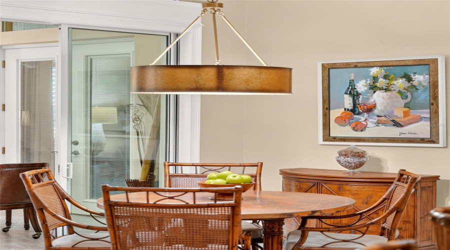 Close-Up View Of Breakfast Room - Shows Hammered Metal Table Top Manufactured In Mexico Which Complements The Cane Back Rattan Chairs.
