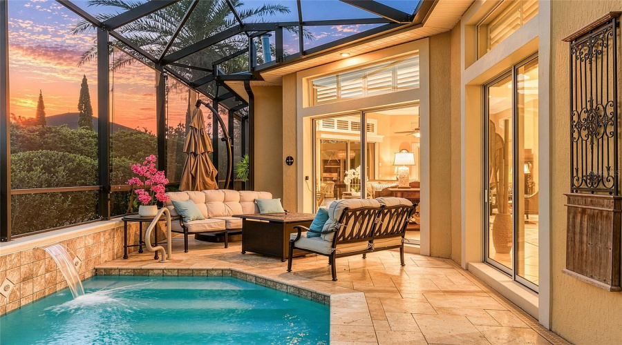 Seating Area On The North End Of The Pool Area @ Twilight/Dusk.  The Expansive Gathering Room Is Available Through The Two Sets Of Sliding Glass Doors. Note Soffitt Lights (Under The Eave Of Roof) That Provides Soft Lighting To Area Under The Mansard Screen Enclosure.