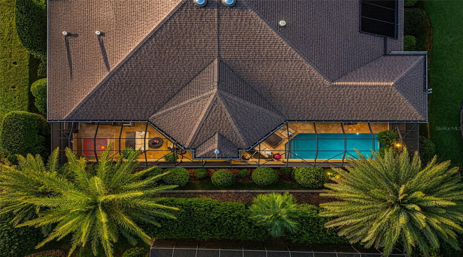 Low Aerial View - Top-Down View Showing The Mansard Screen Enclosure Attached To The Rear Of The  Home, With The Built-In Spa Layout (L) And Rectangular Pool (R) Clearly Visible.