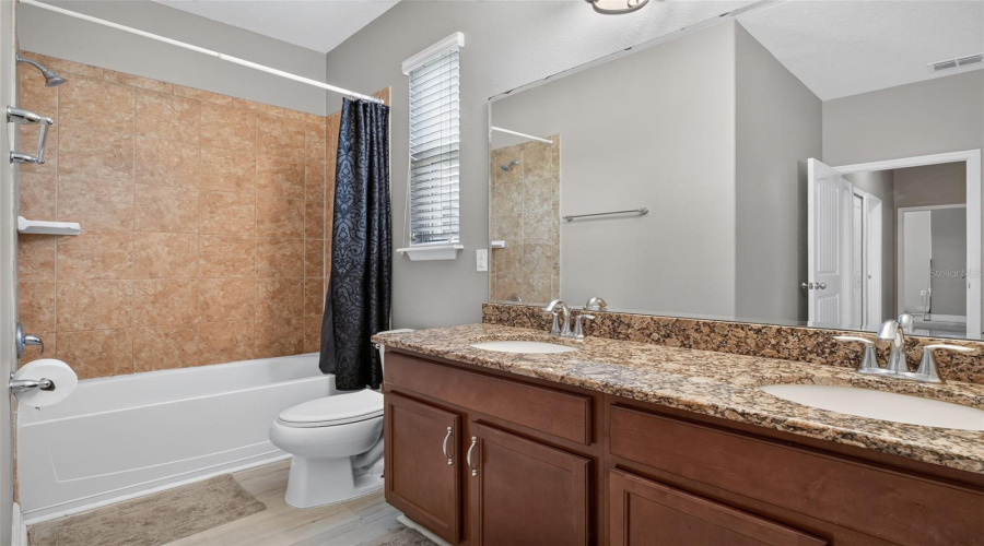 Guest Bathroom Offers Dual Sinks In The Granite Topped Vanity And Custom Tile Work Around Tub.