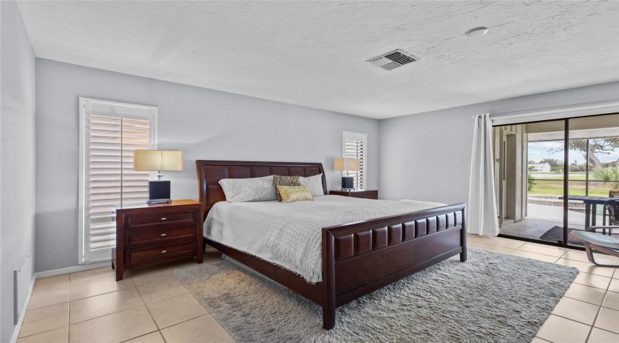Primary Bedroom With Sliders To The Lanai And Pool.