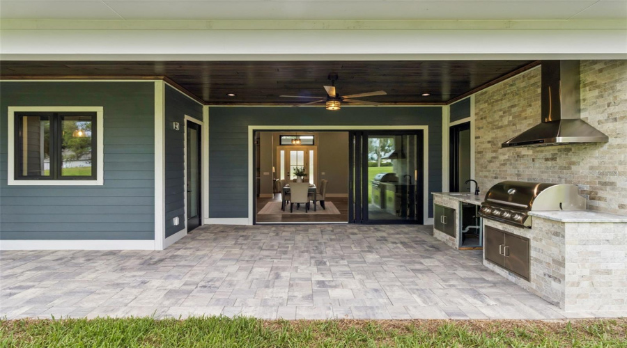 Covered Outdoor Kitchen With Built-In Grill And Entertaining Space