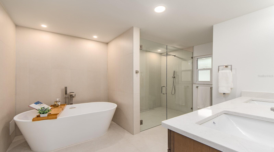 Primary Bath Features Free Standing Tub And A Custom Walk In Shower