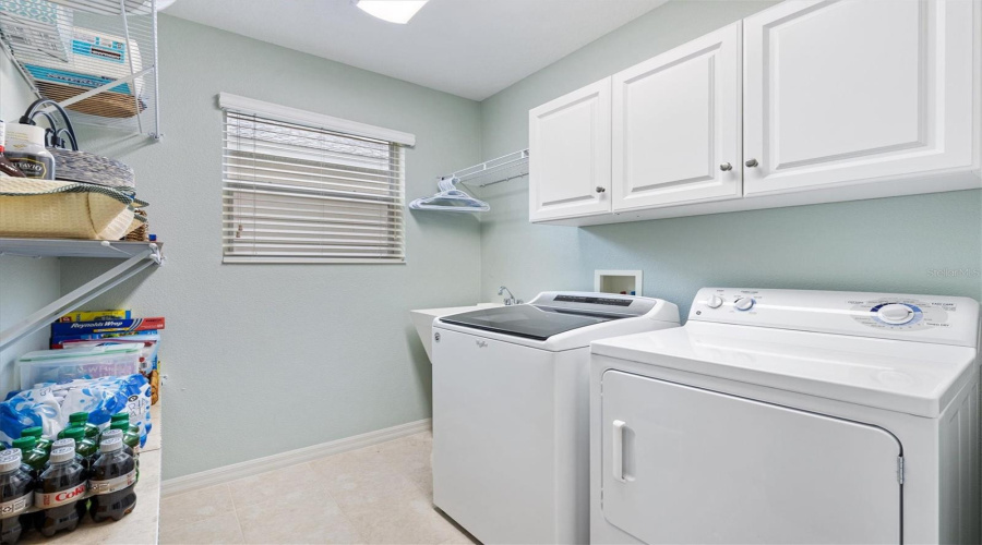 Inside Laundry Room With Cabinets And Storage Shelves