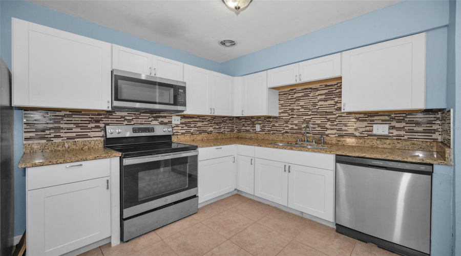 Kitchen With New Cabinets, Granite Countertops, Tile Backsplash And Stainless Steel Appliances