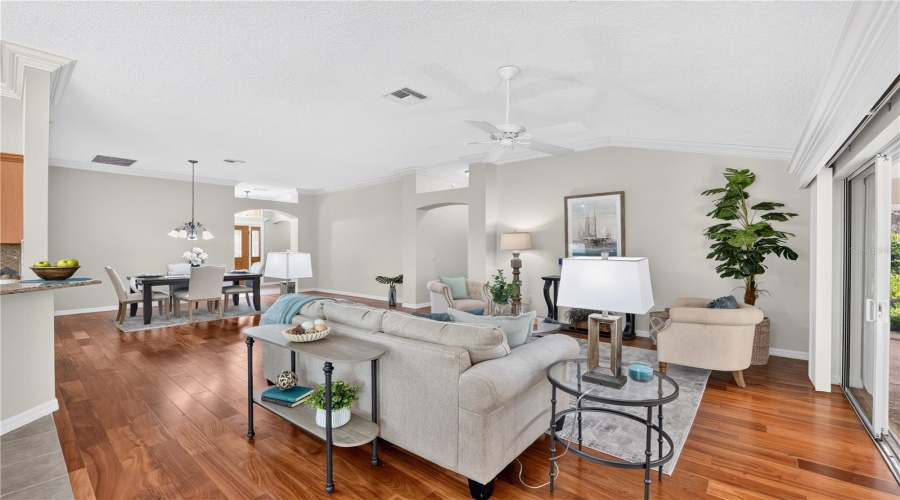 Spacious Open-Concept Living Area Featuring High Ceilings, Abundant Natural Light, And Sliding Glass Doors To The Lanai.