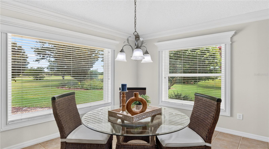 Breakfast Nook Surrounded By Windows, Offering A Bright And Inviting Space To Enjoy Morning Coffee With Scenic Views.