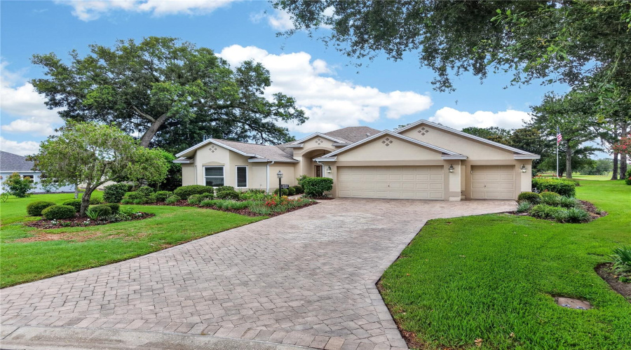 Wide Driveway Approach With Manicured Lawn, Mature Shade Trees, And An Attractive Front Elevation.