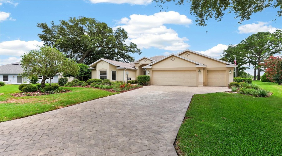 Welcoming Front Approach With Manicured Lawn, Mature Shade Trees, Spacious Driveway, And Beautifully Maintained Exterior.