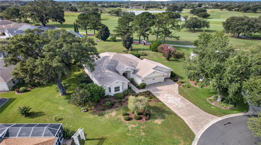 Aerial View Showcasing The Home’s Beautiful Setting, Mature Trees, Long Driveway, And Nearby Golf Course Views.