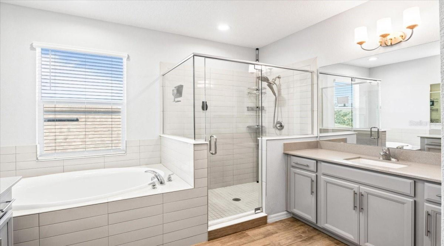 Primary Bathroom With His And Hers Sinks, Spa Tub, Walk In Shower