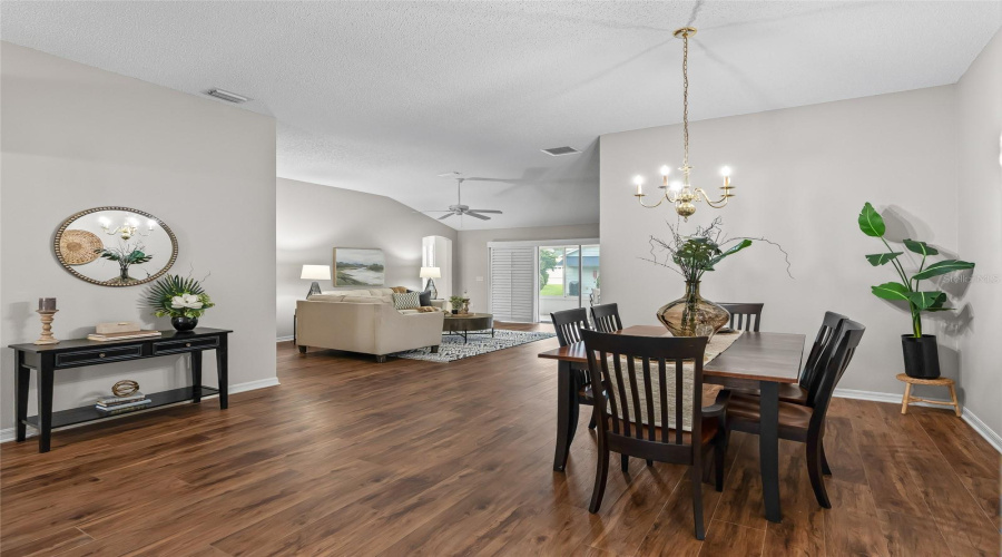 Open-Concept Layout Connects The Dining And Living Spaces Beautifully, With Vaulted Ceilings And Continuous Wood-Look Lvp Flooring Creating A Spacious Feel.
