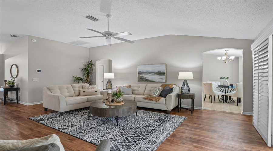 Spacious Living Room With Vaulted Ceiling, Wood-Look Lvp Flooring, And A Flexible Furniture Layout That Makes The Room Feel Open And Comfortable.