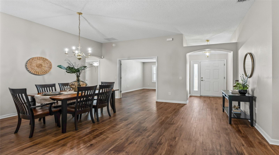 Looking Toward The Front Entry, The Open Dining Area Showcases The Home’s Generous Proportions, Neutral Décor, And Attractive Continuous Flooring.