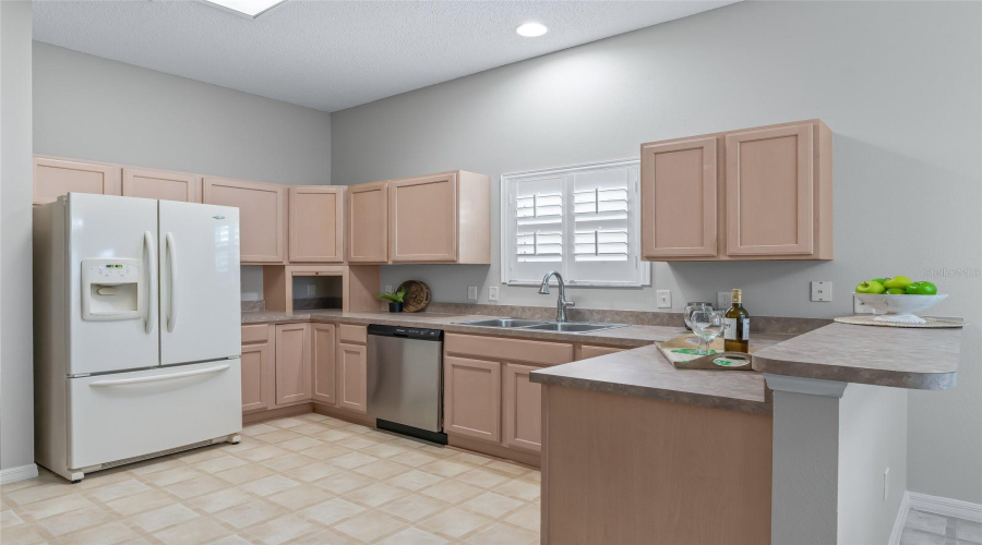 Bright Kitchen With Abundant Storage, Generous Work Surfaces, Stainless Dishwasher, And A Practical Peninsula For Prep Or Casual Serving.