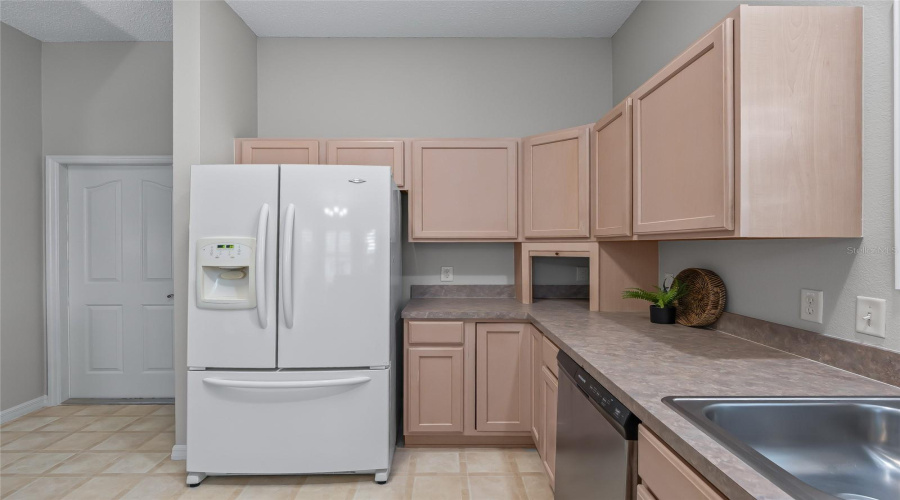 Another View Of The Kitchen Highlights The Excellent Cabinet Storage, Long Stretches Of Counter Space, And Convenient Placement Of The Refrigerator And Sink.