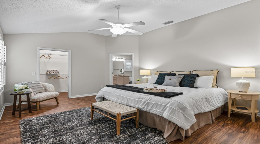 Spacious Primary Bedroom With Newer Wood-Look Lvp Flooring, Neutral Finishes, Ceiling Fan, And Plenty Of Room For Additional Seating Or Furniture.