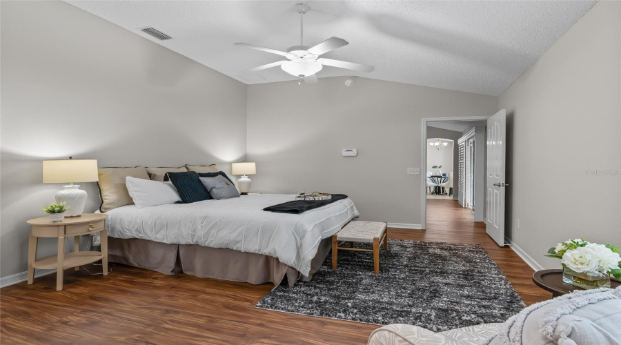 Another View Of The Generous Primary Suite Highlights The Comfortable Proportions, Warm Lvp Flooring, And Convenient Access To The Ensuite Bath And Walk-In Closet.