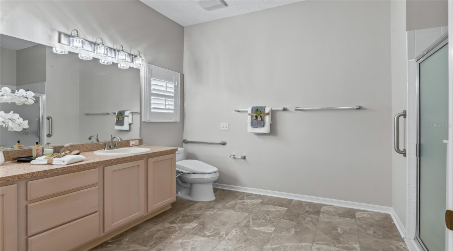 Primary Ensuite Bath Offers A Long Dual-Sink Vanity, Updated Lighting, Walk-In Shower, And A Bidet Toilet Seat For Added Comfort And Convenience.