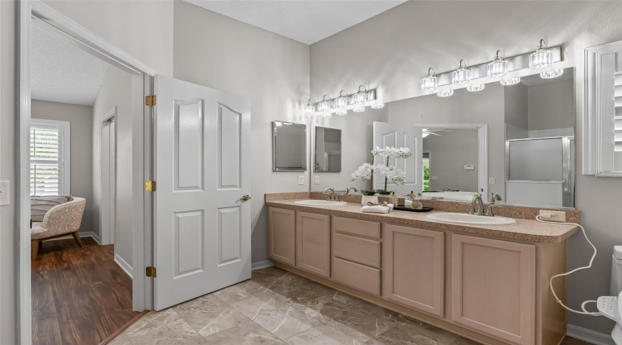Bright Primary Bath With Dual Sinks, Expansive Mirror, Generous Vanity Storage, And Convenient Access From The Bedroom.