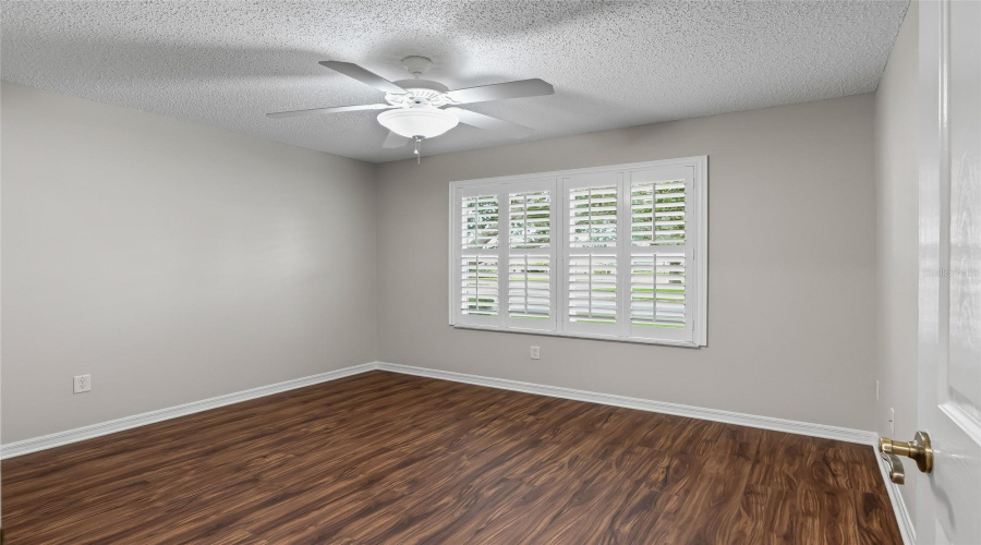 Second Guest Bedroom Offers Plantation Shutters, Ceiling Fan, And Newer Wood-Look Lvp Flooring For A Clean, Comfortable Feel.