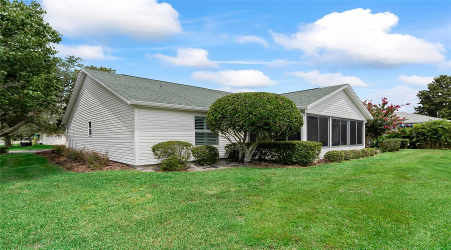 Rear Exterior View Highlights The Home’s Maintained Landscaping, Enclosed Lanai, And Generous Corner-Lot Setting.