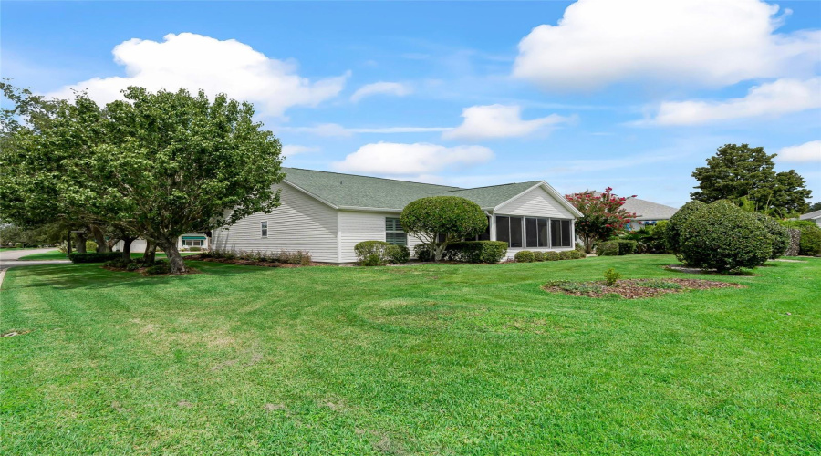 Wide Backyard View Showcases The Spacious Corner Homesite, Mature Trees, And Open Green Space Surrounding The Home.