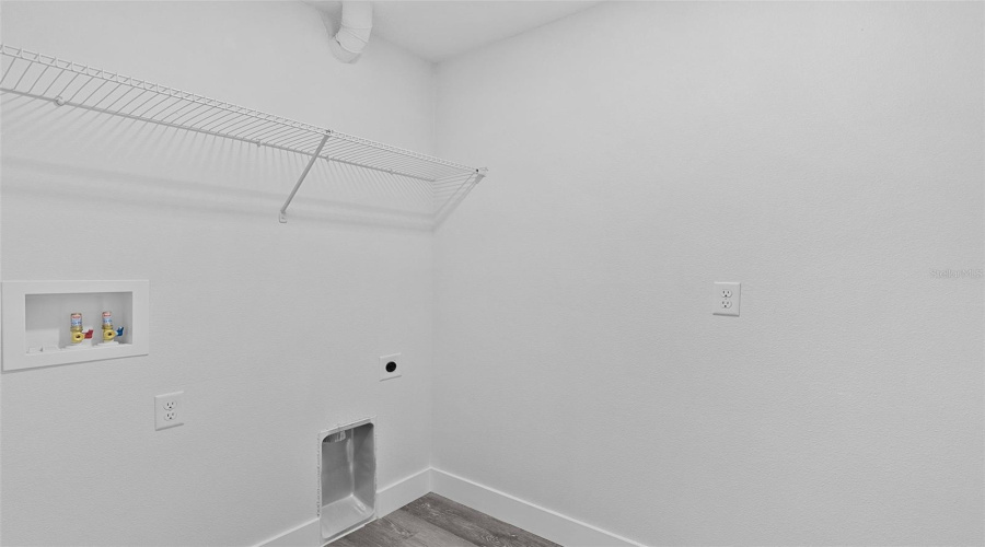 Indoor Laundry With Shelf And Washer And Electric Dryer Connections
