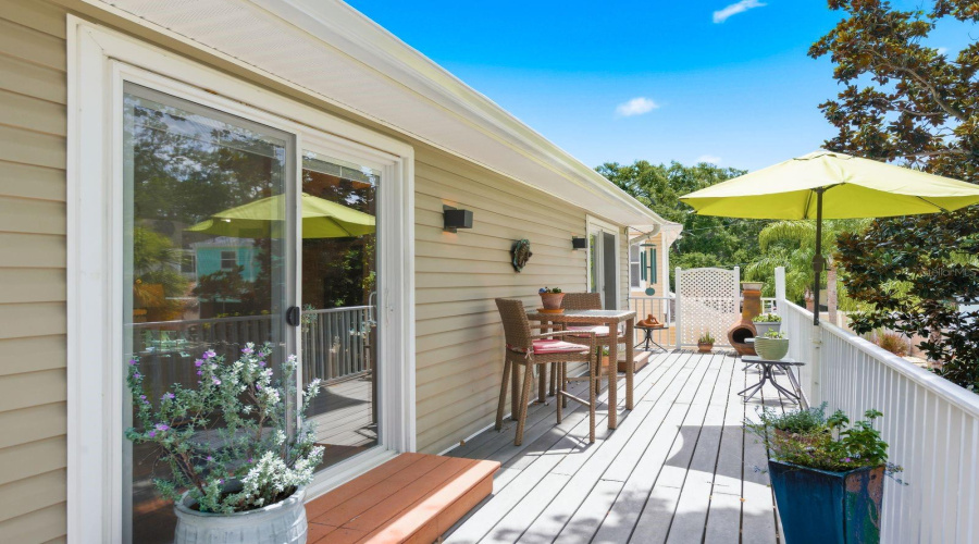 Living Room And Primary Bedroom Sliders Lead To Upstairs Trex Deck Overlooking Landscaped Backyard.