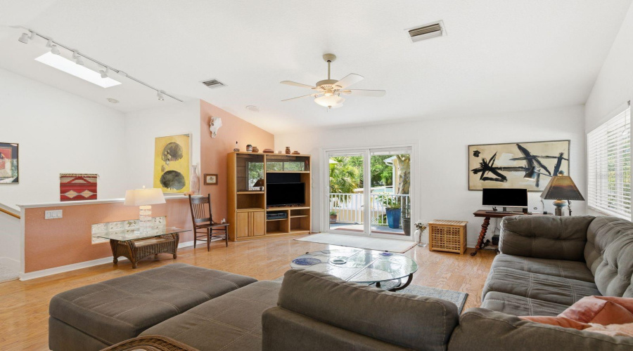 Living Room With Skylight Over Stairs And Sliders To Trex Deck.