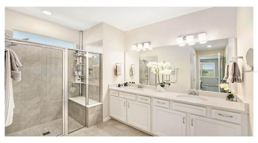 Primary Bath With Dual Vanities And Walk In Shower With Bench