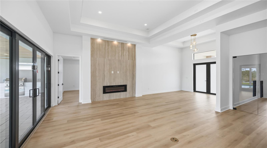 Grand Living Room With Marble Accent Wall And Linear Fireplace.
