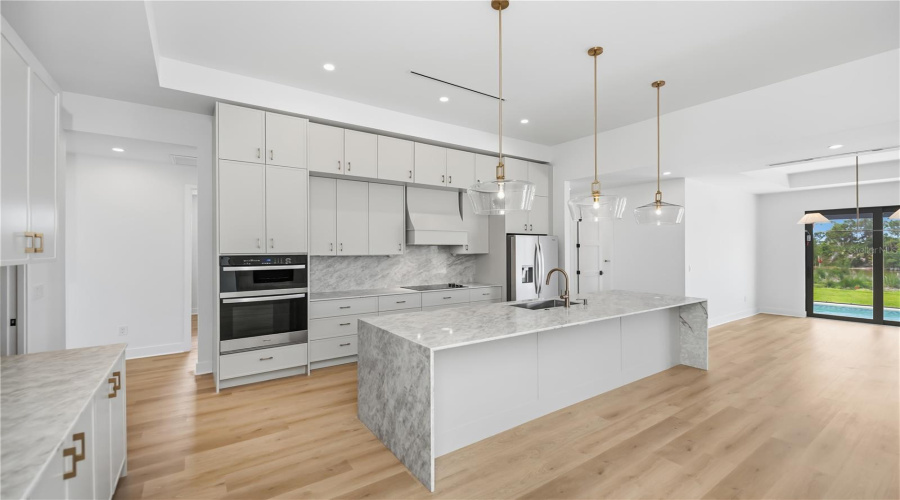 Chef'S Kitchen With Quartz Waterfall Island And Custom Cabinetry.