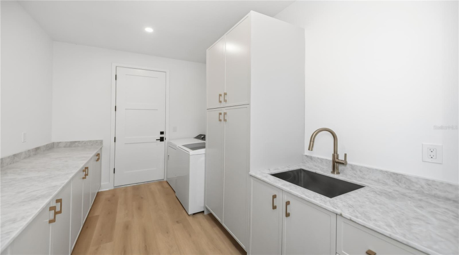 Spacious Laundry Room With Utility Sink And Ample Storage.