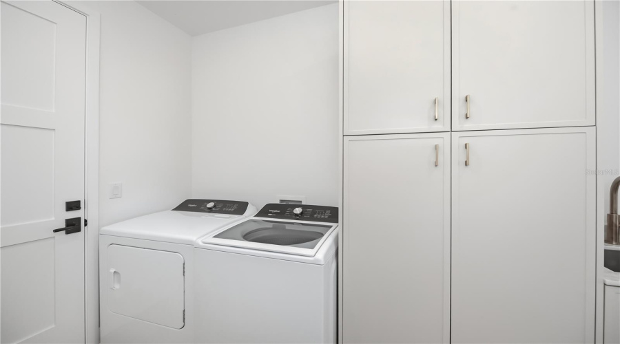Spacious Laundry Room With Utility Sink And Ample Storage.