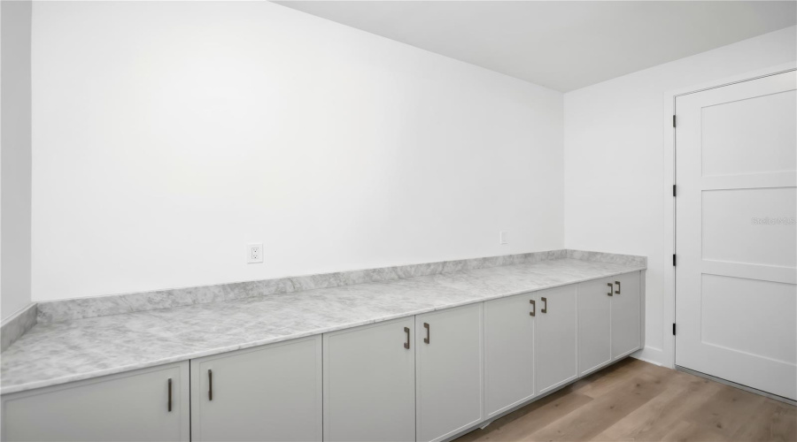 Spacious Laundry Room With Utility Sink And Ample Storage.