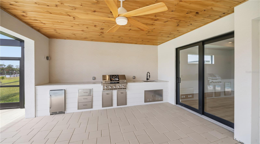 Outdoor Kitchen With Built-In Grill And Beverage Fridge.