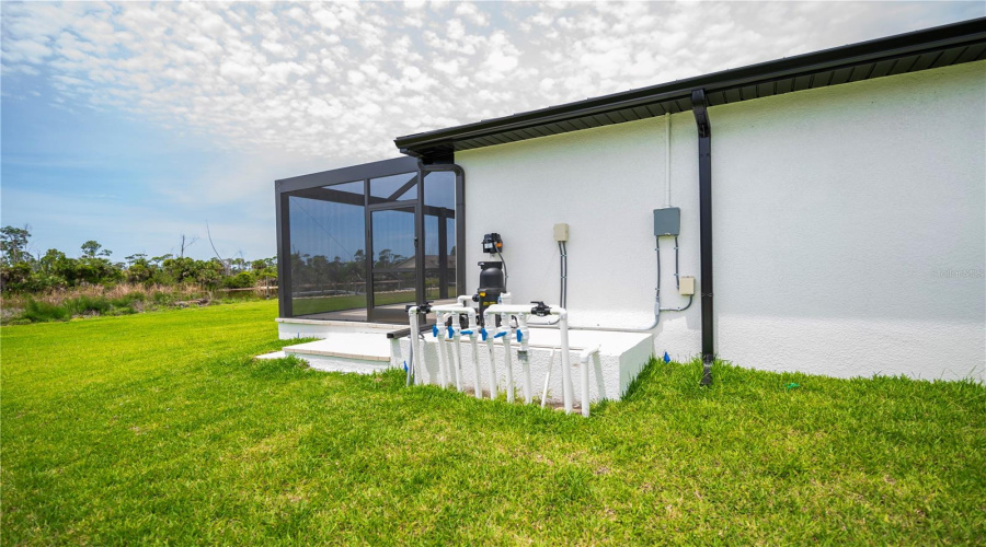Exterior Utility Area Featuring Pool Equipment And Irrigation Controls.