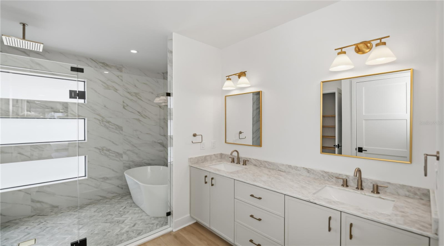 Spa-Inspired Primary Ensuite Featuring Dual Vanities, Soaking Tub, And Glass-Enclosed Walk-In Shower.