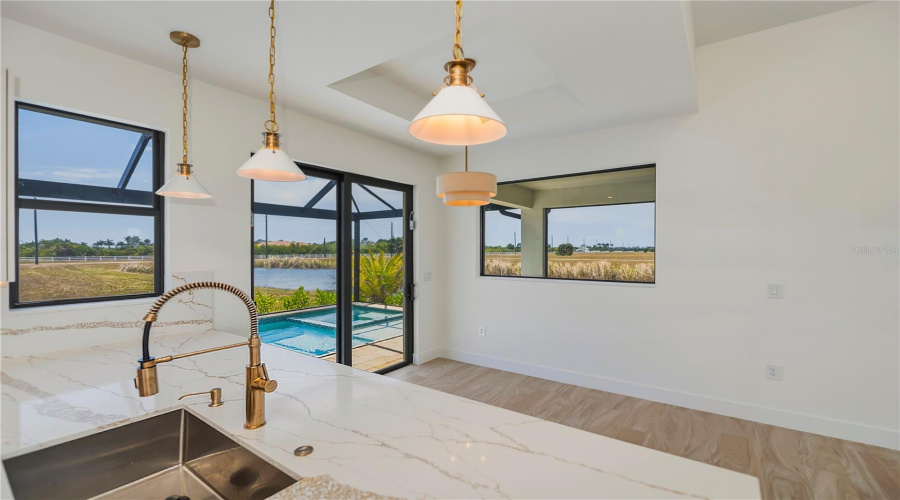 Dining Area Has Pendant Lighting And Waterfront Views.