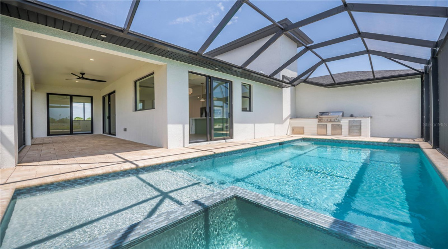 Modern Pool With Built In Jacuzzi And Outdoor Kitchen